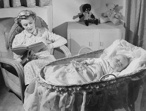 Woman reads while baby sleeps - advertising image from c. 1949